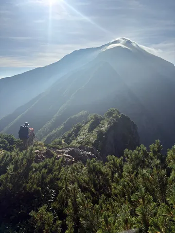 雄大な山岳風景に溶け込む二人