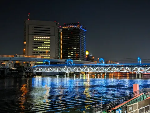 都会の夜景、水面に映る光のシンフォニー