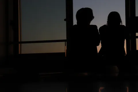 夕暮れ時の窓辺、二人のシルエット