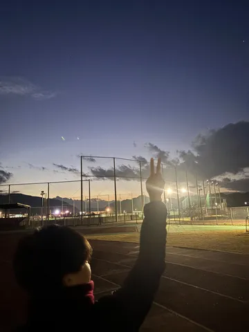 夕暮れ、二本指のピースサイン