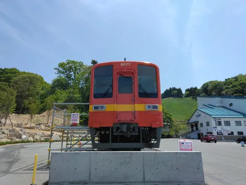 青空と緑に映える赤い電車