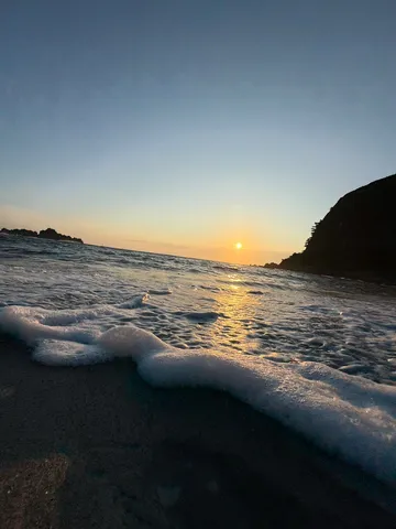 夕陽と波打ち際の泡