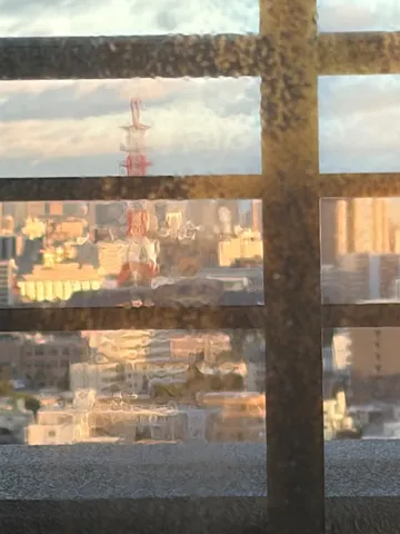 窓越しの街へと夕光の影
