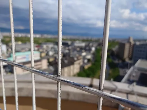 金網越しの都会の空