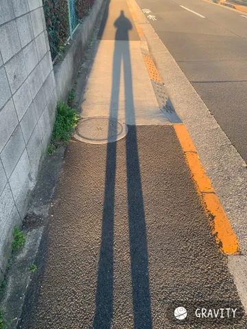 伸びる影に映る、夕暮れの道