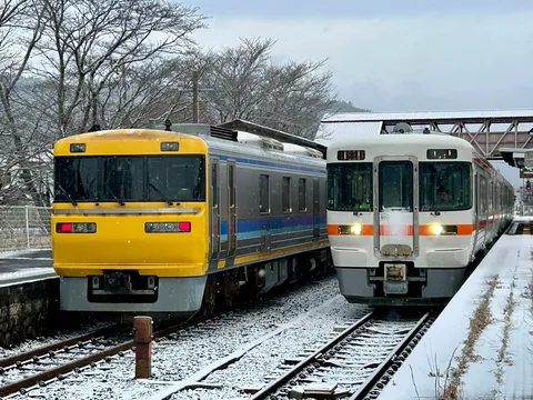 雪化粧の駅、対照的な二つの列車