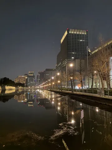 都会の夜景、水面に映る光の回廊