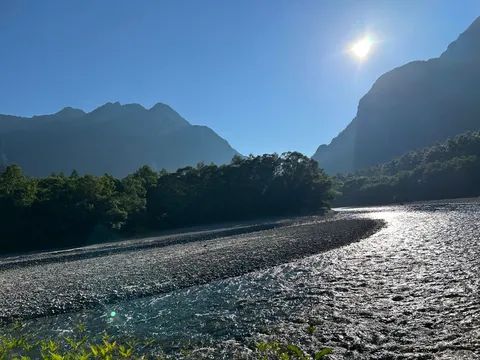 朝日に輝く渓流と山並み