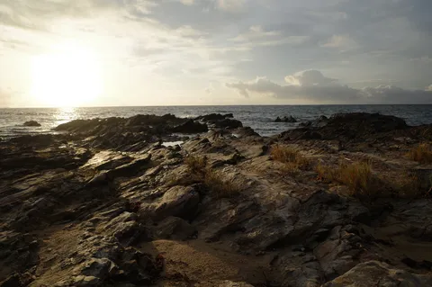 岩礁に寄せる波と夕日