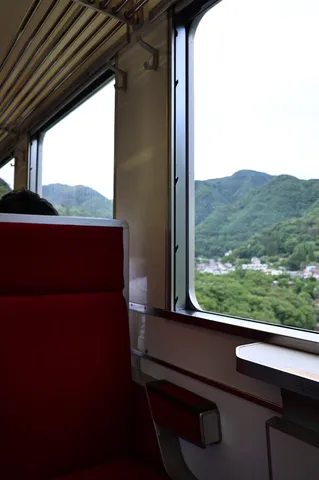 窓から見える緑の山と町並み