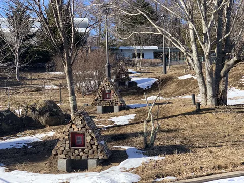 雪残る丘に立つ三角小屋