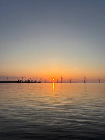 風力発電と夕日、海辺の風景