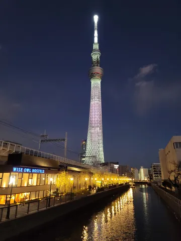 都会の夜景と水面に映る光の道