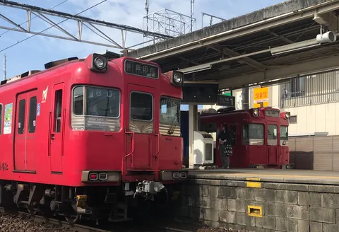 赤い電車が行き交う駅の風景