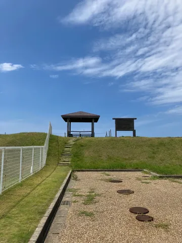 青空の下、休憩所と草原の風景