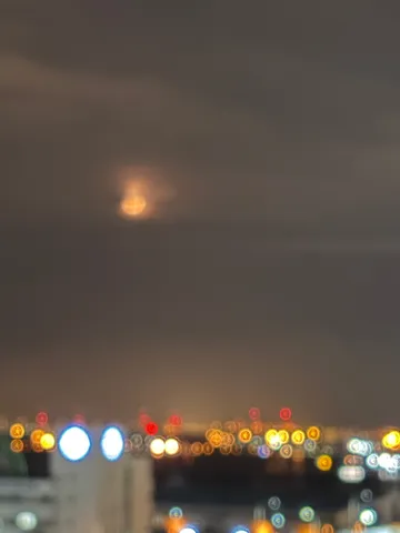 都市の灯りと胧月