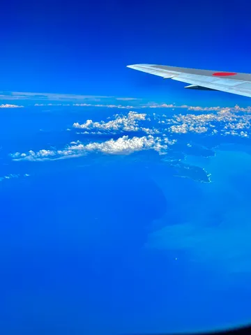 飛行機から見た、空と海と雲の青