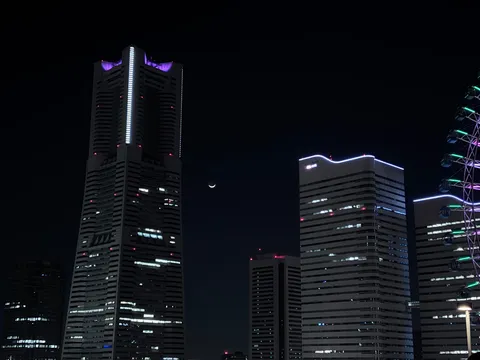 都会の夜空に浮かぶ月と光