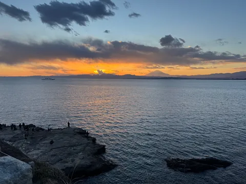 海に溶けゆく夕焼けと遠景の富士