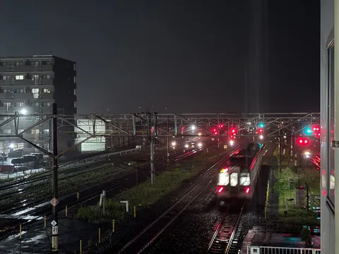 雨夜の鉄路、電車の光跡
