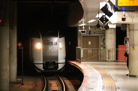 夜のホームに灯る列車の影