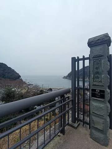 曇り空に佇む、海辺の橋のたもと