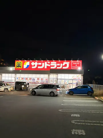 夜の駐車場、薬局の明かり