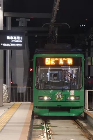 夜の駅に停車中の緑の電車