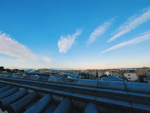 夕暮れの瓦屋根と広い空