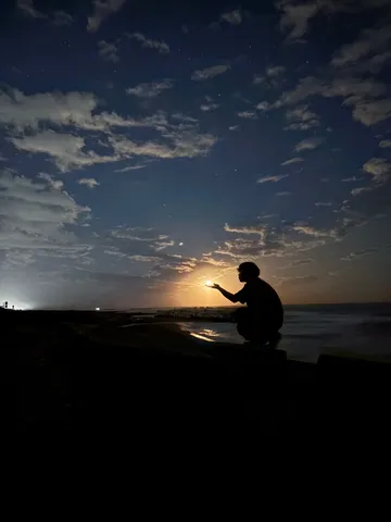 夜の海辺に灯る掌