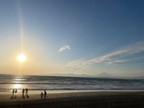 波間に沈む太陽と人影