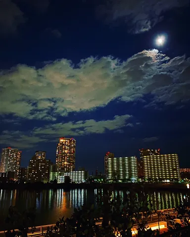 都会の夜景に浮かぶ月明かり