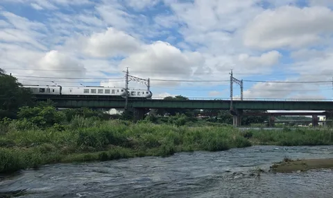 川面を渡る緑の鉄橋と白い列車