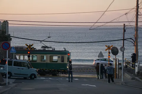 夕暮れ、線路と海を望む交差点