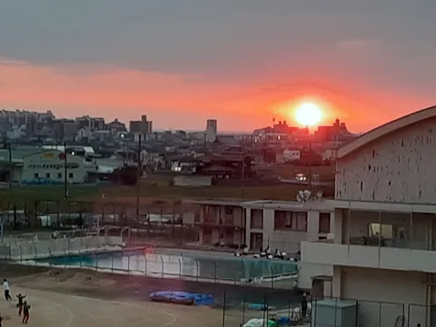 夕暮れ時のグラウンドと街並み