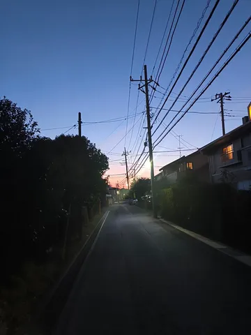 夕暮れ時の電線と住宅街