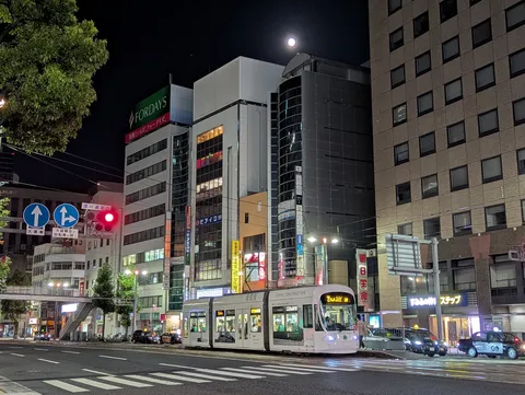 都会の夜、月と路面電車