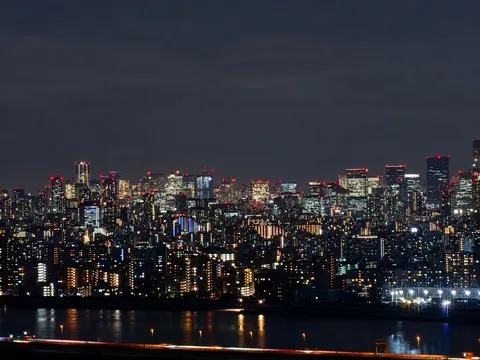 夜の水辺に映る都市の灯