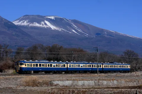 雪化粧の山と青い電車