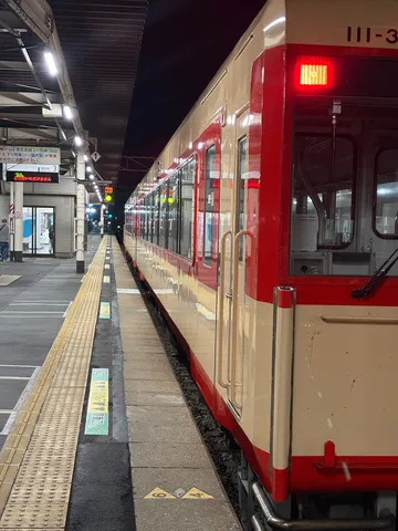 夜の駅、赤い光がまぶしい