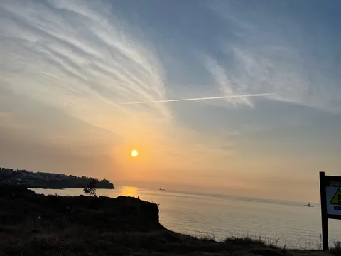 岸壁に沈む夕陽と雲の流れ