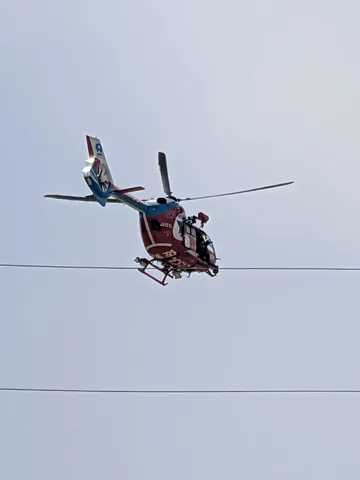 電線と舞う赤いヘリコプター
