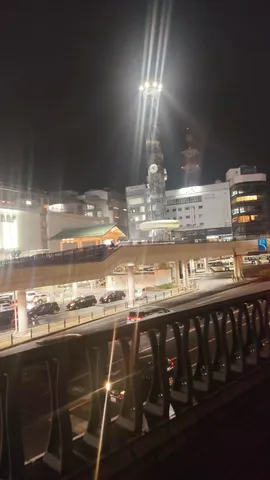 都会の夜景、空へ伸びる光の道