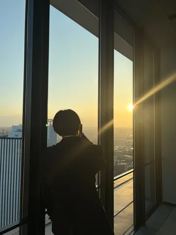 窓辺に立つ夕暮れのシルエット
