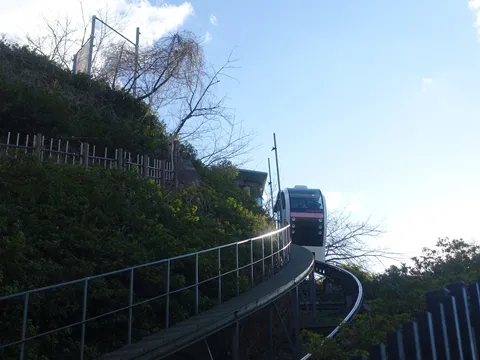 青空と坂道を駆け上がる列車