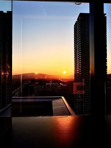 都市の窓に輝く双つの陽