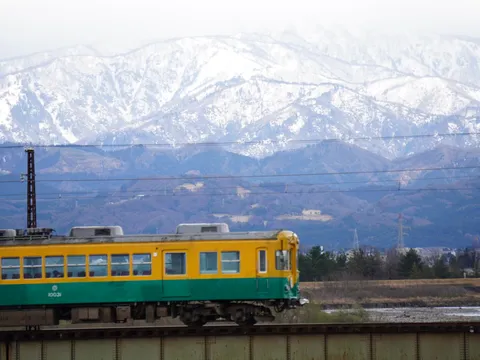 雪山とローカル列車のコントラスト