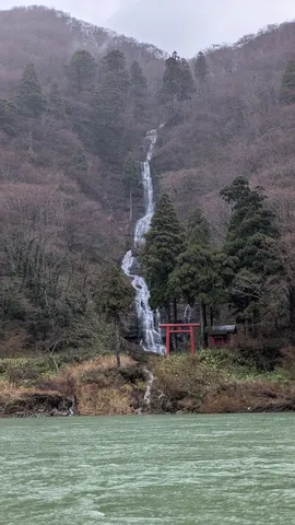 山肌を流れる神秘の滝と朱色の鳥居