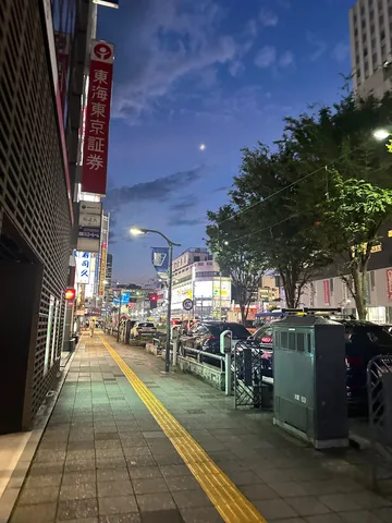 夜の街路に浮かぶ青い空と月