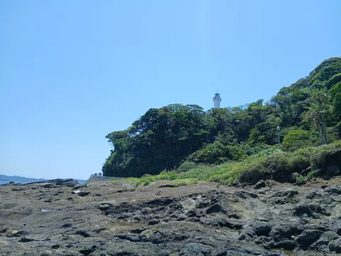 海岸の灯台と緑の山肌